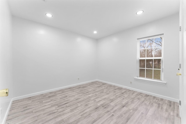 spare room featuring recessed lighting, baseboards, and wood finished floors