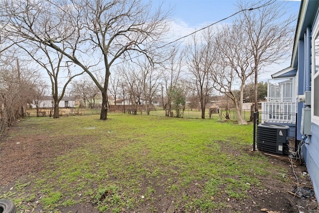 view of yard with central air condition unit and fence