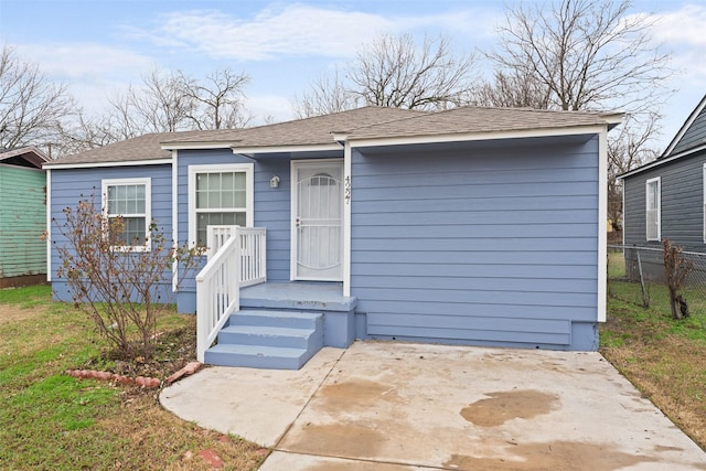 view of front facade with a patio and fence