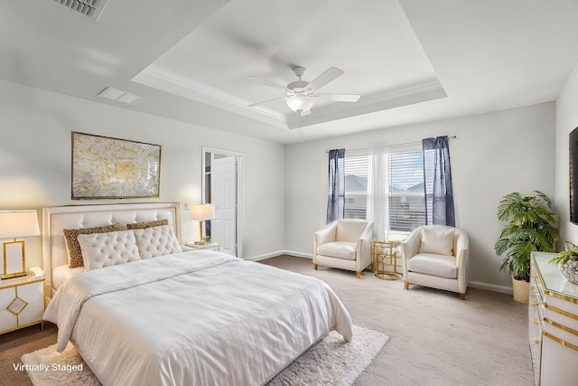 carpeted bedroom featuring ceiling fan, crown molding, and a raised ceiling