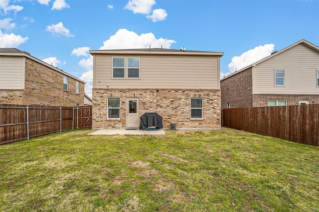 rear view of property featuring a lawn and a patio area