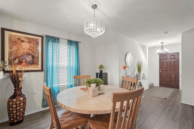 dining space with dark hardwood / wood-style flooring and an inviting chandelier