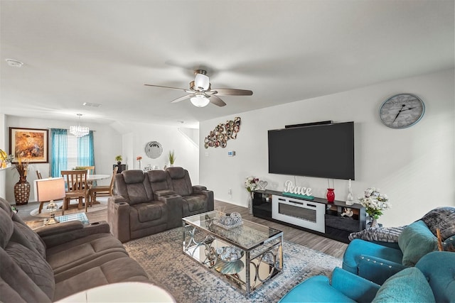 living room featuring hardwood / wood-style flooring and ceiling fan with notable chandelier