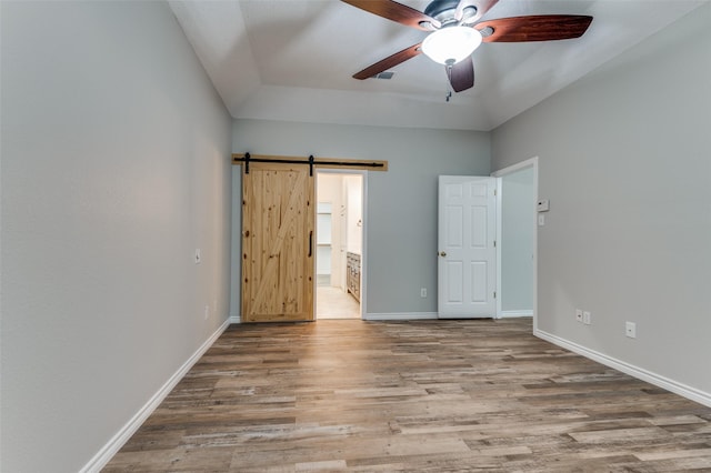 1230 Wooded Trl, Hurst, TX 76053 - unfurnished bedroom with wood finished floors, a barn door, ensuite bath, and baseboards