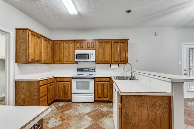 1230 Wooded Trl, Hurst, TX 76053 - kitchen featuring white appliances, a sink, brown cabinetry, a peninsula, and a textured ceiling