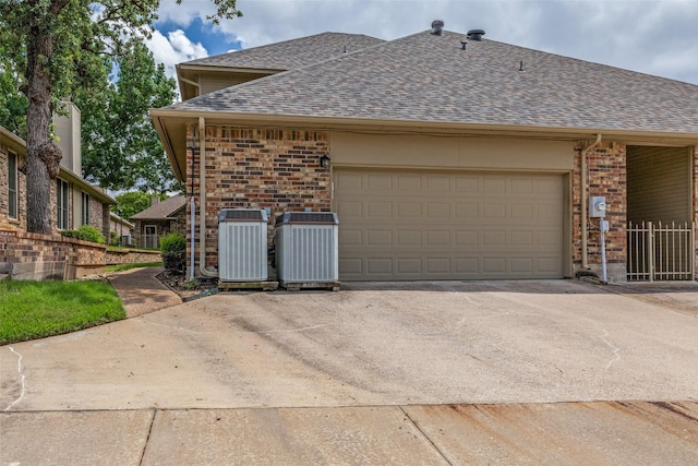 1230 Wooded Trl, Hurst, TX 76053 - view of side of home featuring a shingled roof, brick siding, central AC, and concrete driveway
