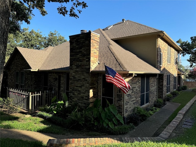 1230 Wooded Trl, Hurst, TX 76053 - view of side of property featuring roof with shingles, a chimney, and brick siding