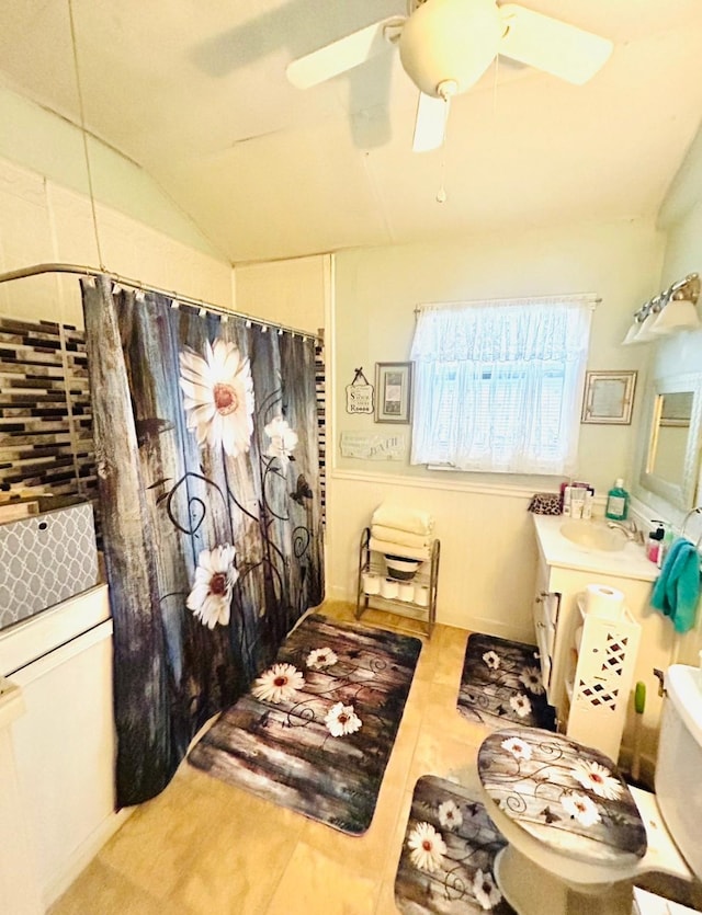 bathroom featuring tile patterned floors, toilet, vaulted ceiling, vanity, and ceiling fan