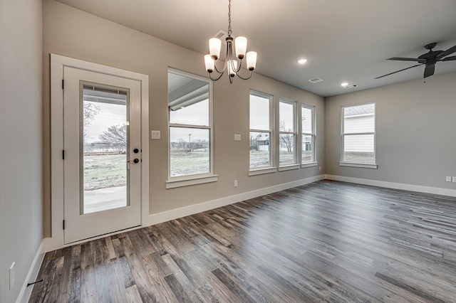 unfurnished dining area featuring dark hardwood / wood-style flooring and ceiling fan with notable chandelier