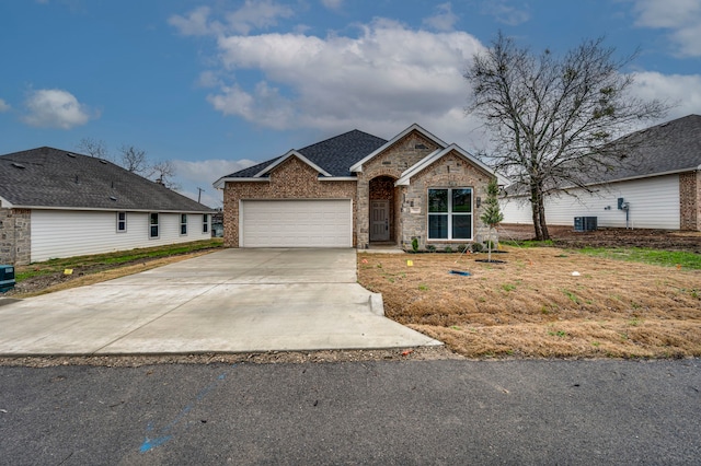 view of front of home with central AC and a garage