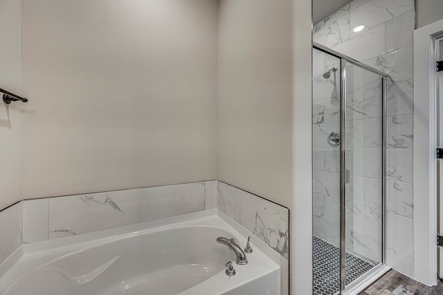 bathroom featuring shower with separate bathtub