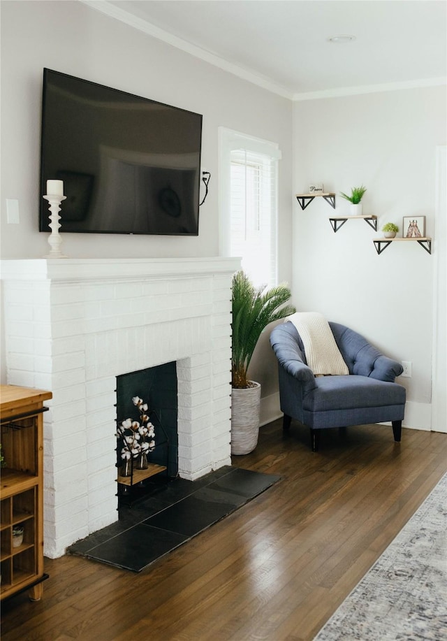 sitting room featuring crown molding, dark hardwood / wood-style flooring, and a brick fireplace