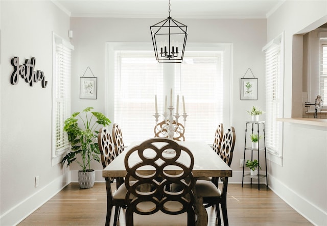 dining room with crown molding, a chandelier, and light wood-type flooring