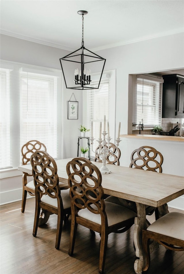 dining space with wood-type flooring and ornamental molding