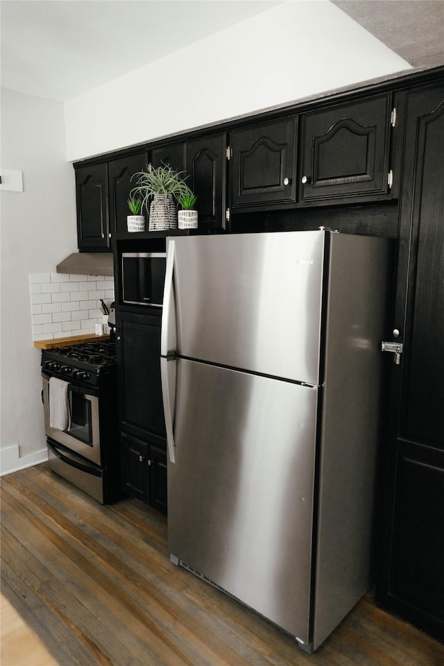 kitchen featuring backsplash, dark wood-type flooring, and appliances with stainless steel finishes