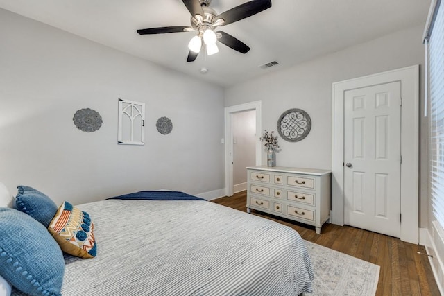 bedroom featuring dark wood finished floors, visible vents, and a ceiling fan
