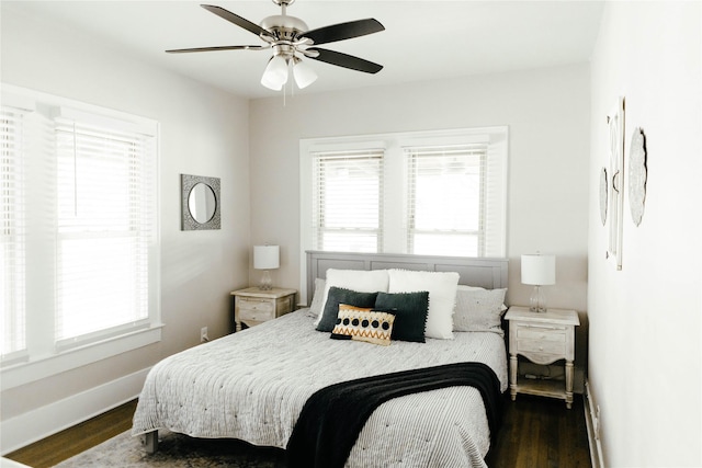 bedroom featuring dark wood-type flooring, ceiling fan, and multiple windows