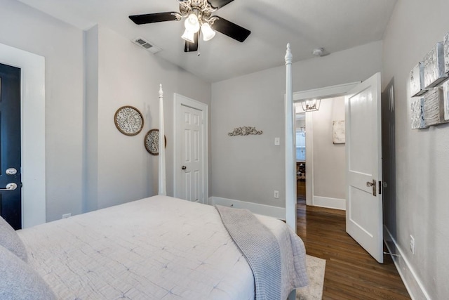 bedroom featuring baseboards, dark wood-style flooring, visible vents, and ceiling fan with notable chandelier