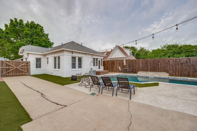 exterior space with a patio area, a fenced backyard, a fenced in pool, and brick siding