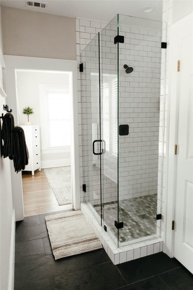 bathroom with walk in shower and hardwood / wood-style flooring