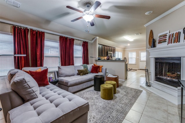 tiled living room featuring crown molding and ceiling fan