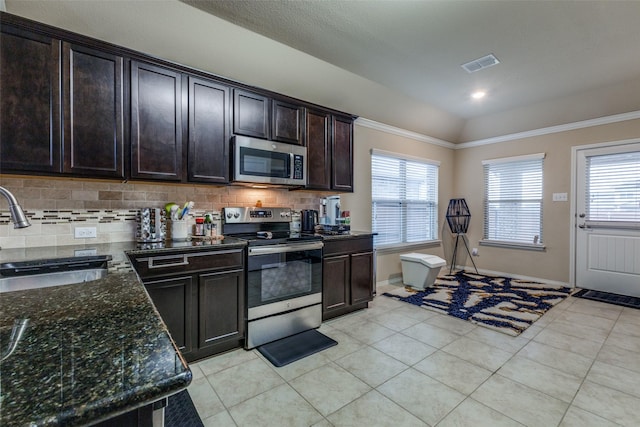 kitchen featuring sink, appliances with stainless steel finishes, dark stone countertops, backsplash, and dark brown cabinets