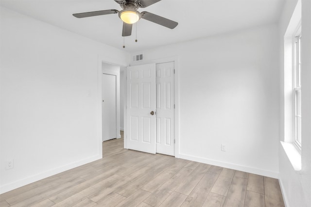 unfurnished bedroom with ceiling fan, multiple windows, a closet, and light hardwood / wood-style flooring