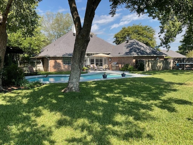 view of swimming pool with a lawn