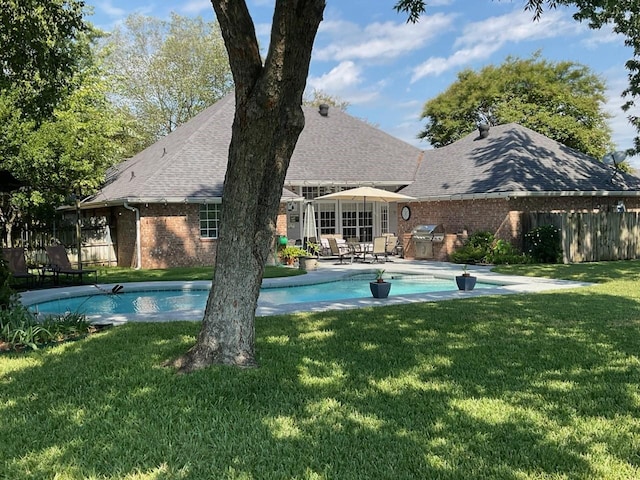 view of swimming pool featuring a grill and a lawn