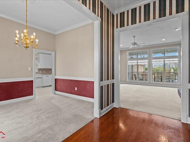 empty room featuring ornamental molding, carpet, and ceiling fan with notable chandelier