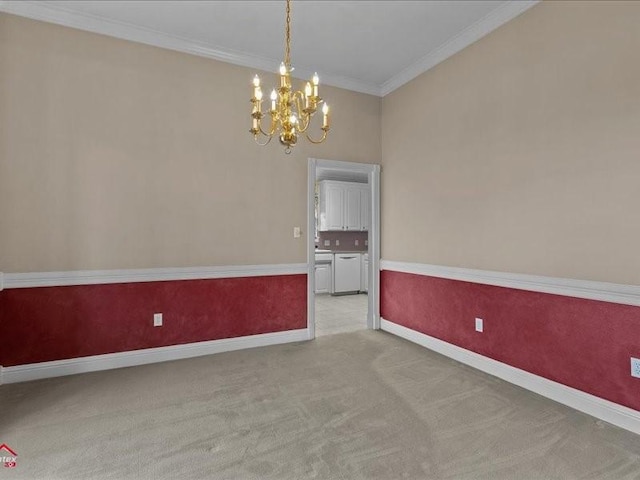 carpeted spare room with an inviting chandelier and ornamental molding