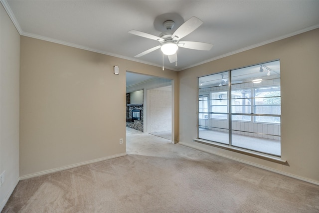 unfurnished room featuring a brick fireplace, ornamental molding, light colored carpet, and ceiling fan