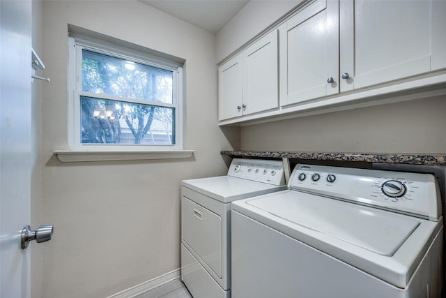 clothes washing area with cabinets and independent washer and dryer