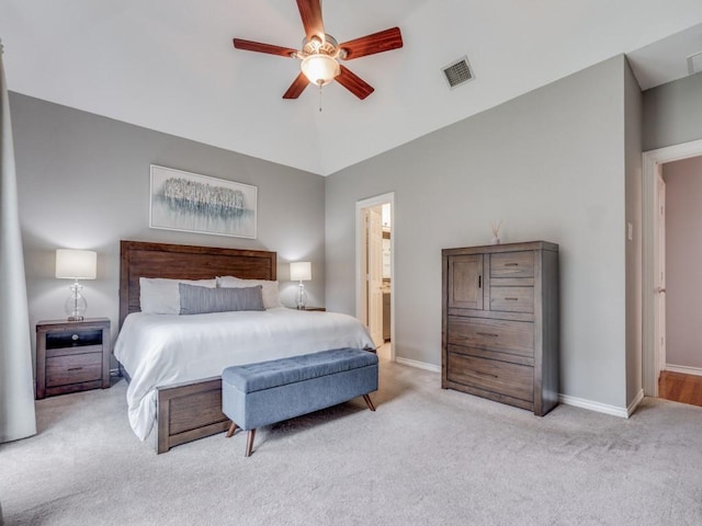 carpeted bedroom with ensuite bathroom, lofted ceiling, and ceiling fan