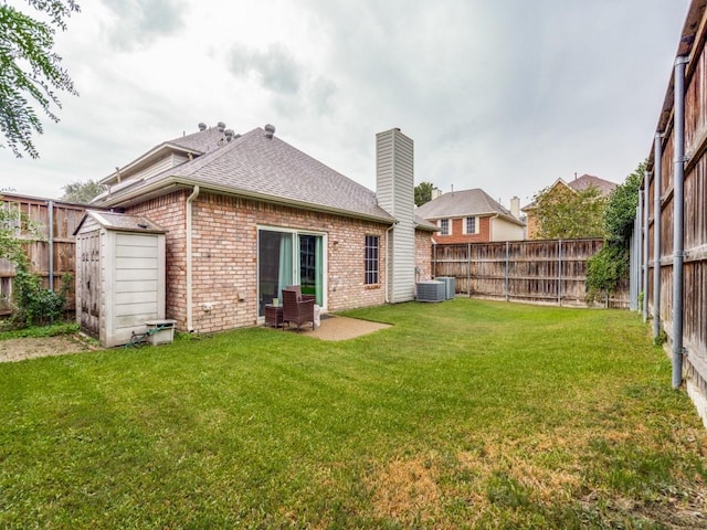 back of property featuring a lawn, central AC, a patio area, and a storage shed