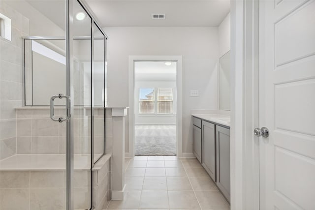 bathroom featuring tile patterned flooring, vanity, and walk in shower