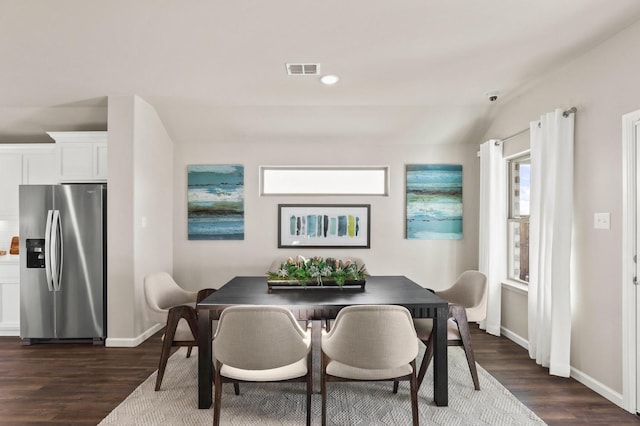 dining room featuring dark wood-type flooring and lofted ceiling