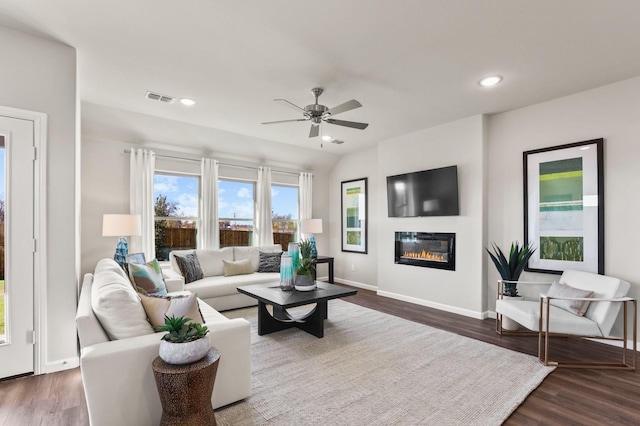 living room featuring dark wood-type flooring and ceiling fan