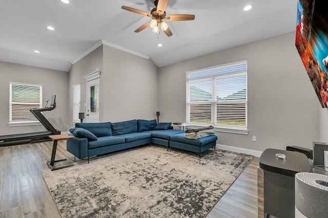 living room with lofted ceiling, wood-type flooring, ornamental molding, and ceiling fan