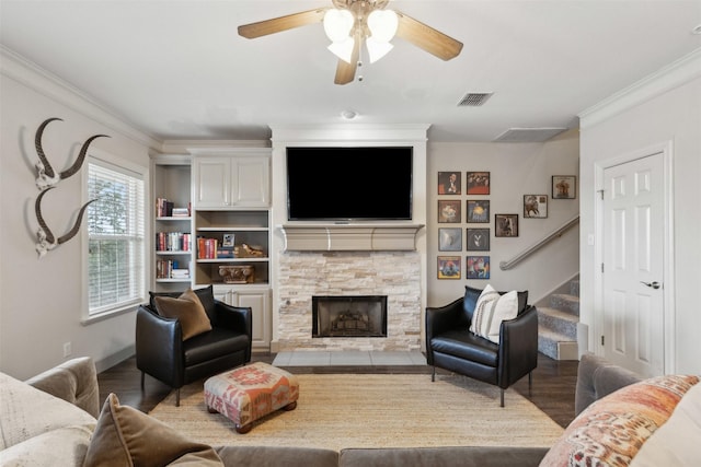 living room featuring hardwood / wood-style floors, crown molding, a fireplace, and ceiling fan