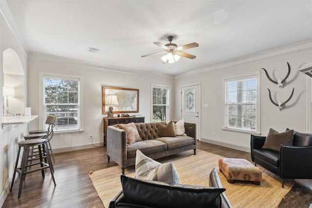 living room with ornamental molding, a healthy amount of sunlight, ceiling fan, and dark hardwood / wood-style flooring