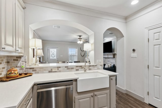 kitchen with sink, dishwasher, ornamental molding, white cabinets, and kitchen peninsula