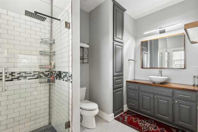 bathroom with vanity, toilet, tile patterned flooring, and a shower with door