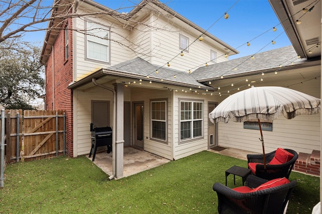 rear view of property featuring a yard and a patio area