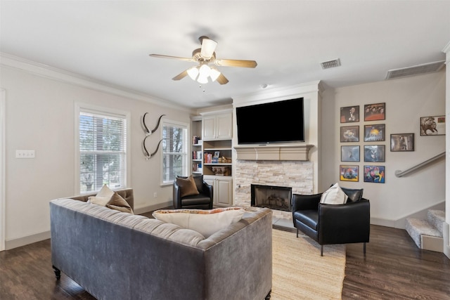 living room with a fireplace, wood-type flooring, ornamental molding, and ceiling fan