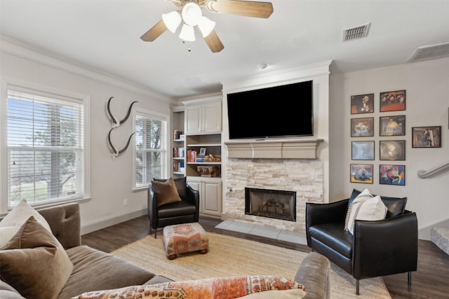 living room with hardwood / wood-style floors, a fireplace, ornamental molding, and ceiling fan