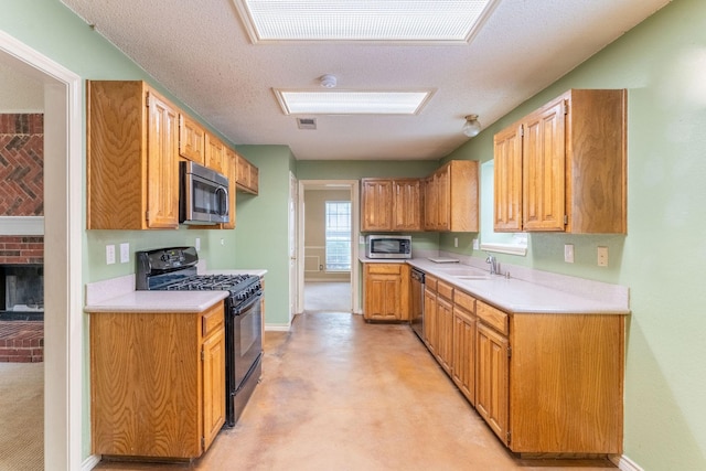 kitchen featuring appliances with stainless steel finishes, light countertops, a sink, and visible vents