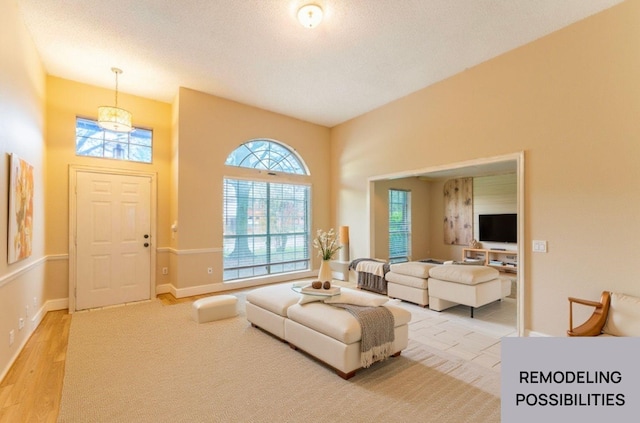 interior space featuring a textured ceiling, plenty of natural light, wood finished floors, and baseboards