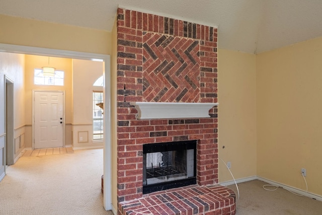 unfurnished living room featuring carpet floors, a brick fireplace, baseboards, and lofted ceiling