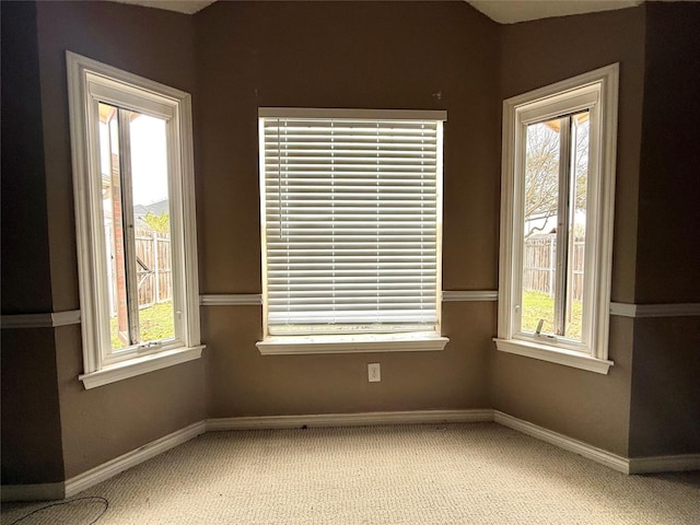 spare room with light carpet and baseboards